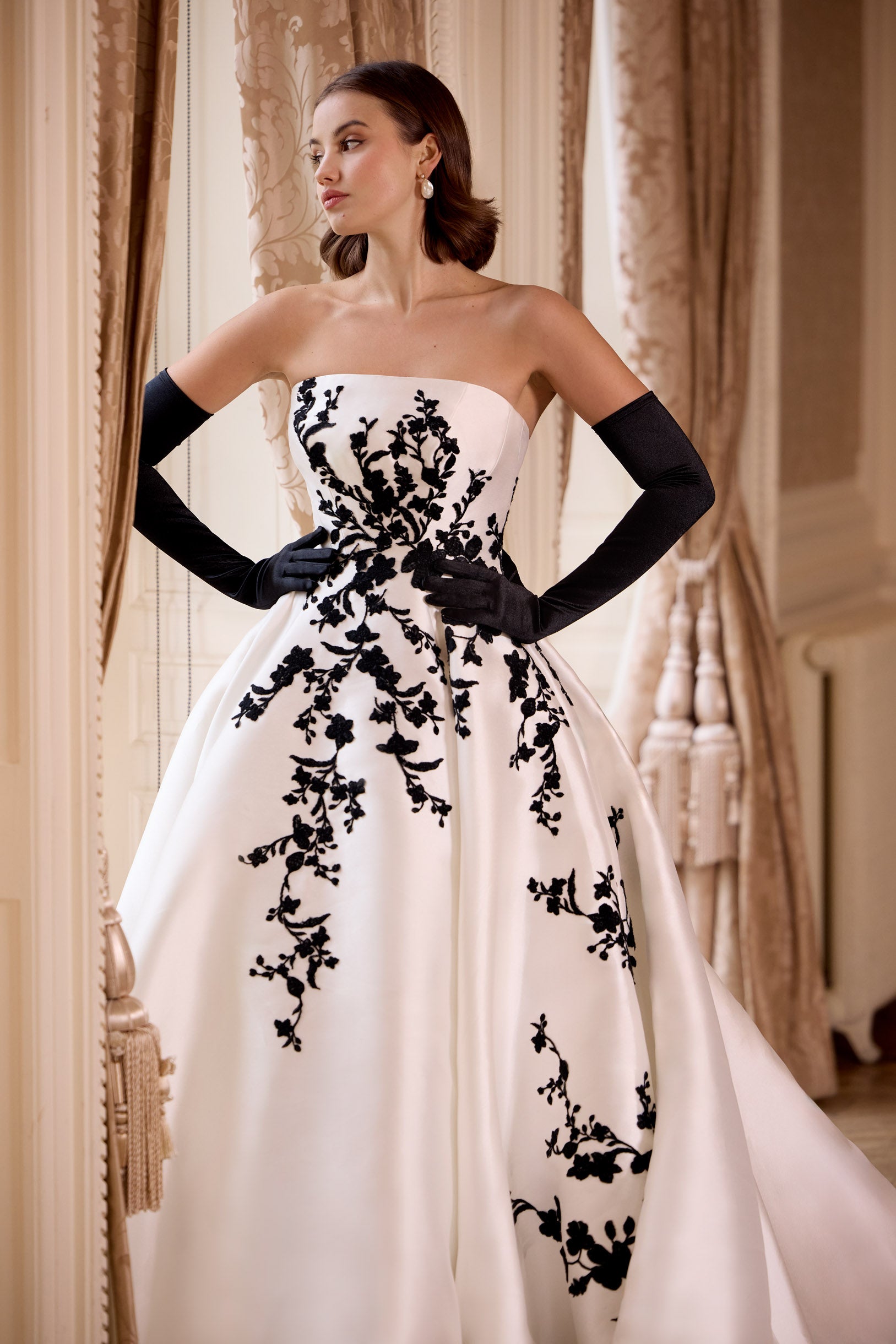 straight strapless neckline A-line dress with black lace with dramatic train and long black gloves and bows