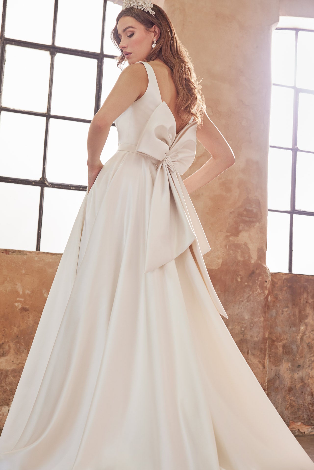 Full skirted a-line gown with flattering neckline, detachable belt and bow. Sumptuous satin with inner corset, full circle skirt with concealed pockets.