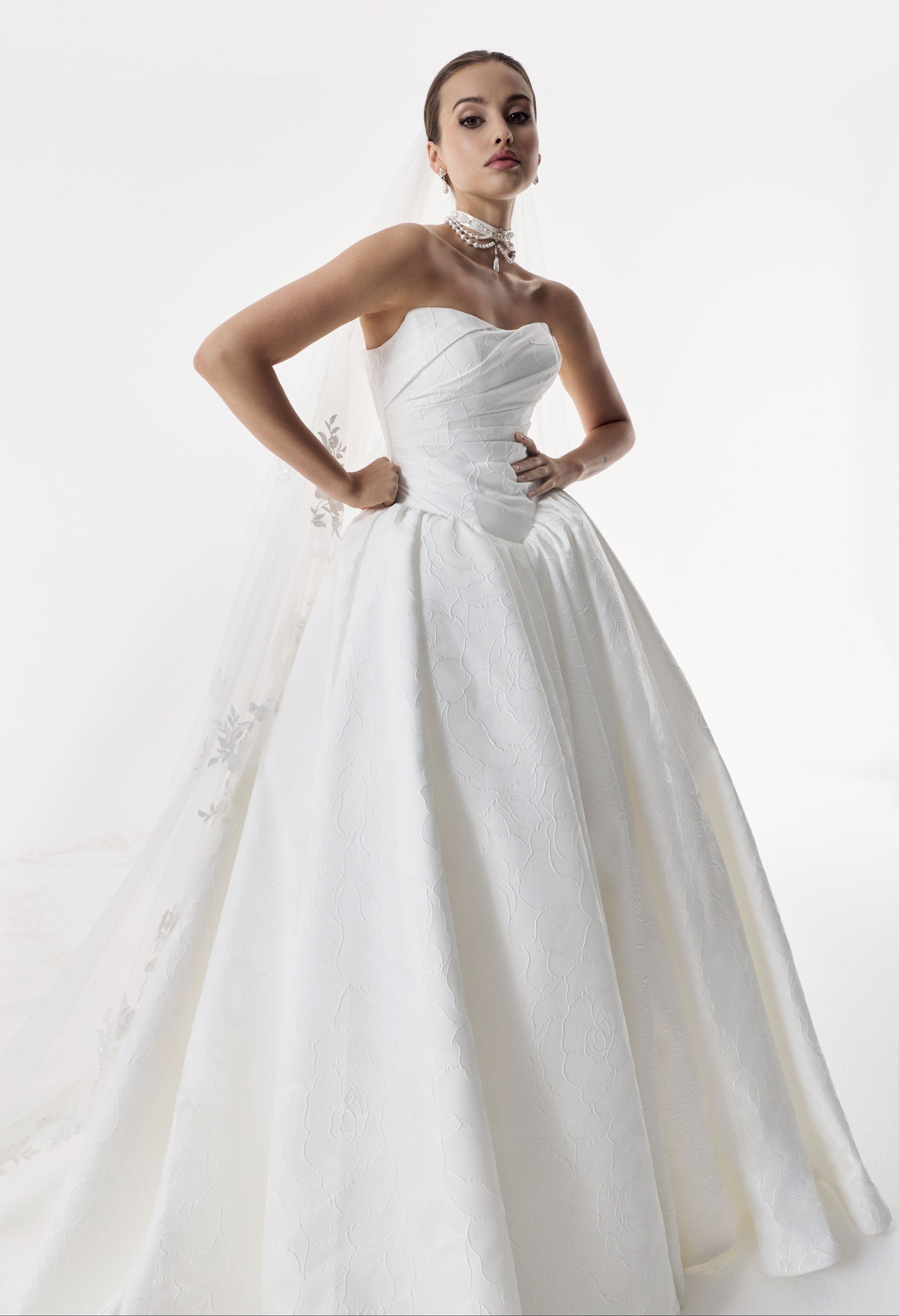 strapless cat eye neckline with sculptural structured pleated bodice and a basque waist and full A-line ballgown skirt