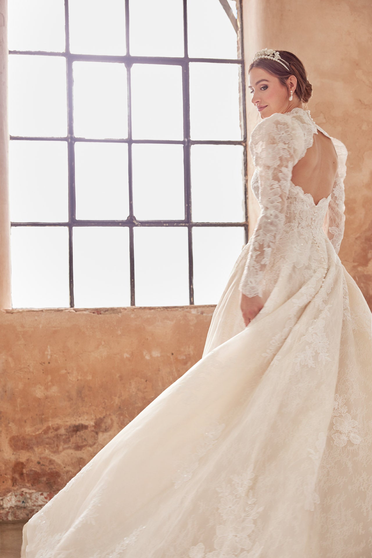 High-neck luxury lace A-line gown with romantic long puffed sleeves. Finest embroidered lace with a full skirt. Keyhole back and full length covered buttons on train.