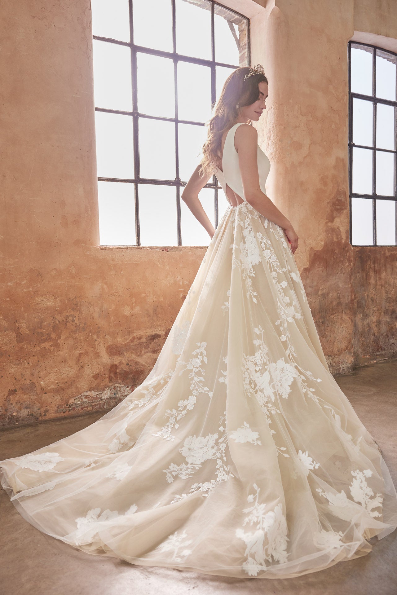 Ballgown with soft layers of tulle and floral applique lace on skirt, crepe v-neck bodice and key-hole back.