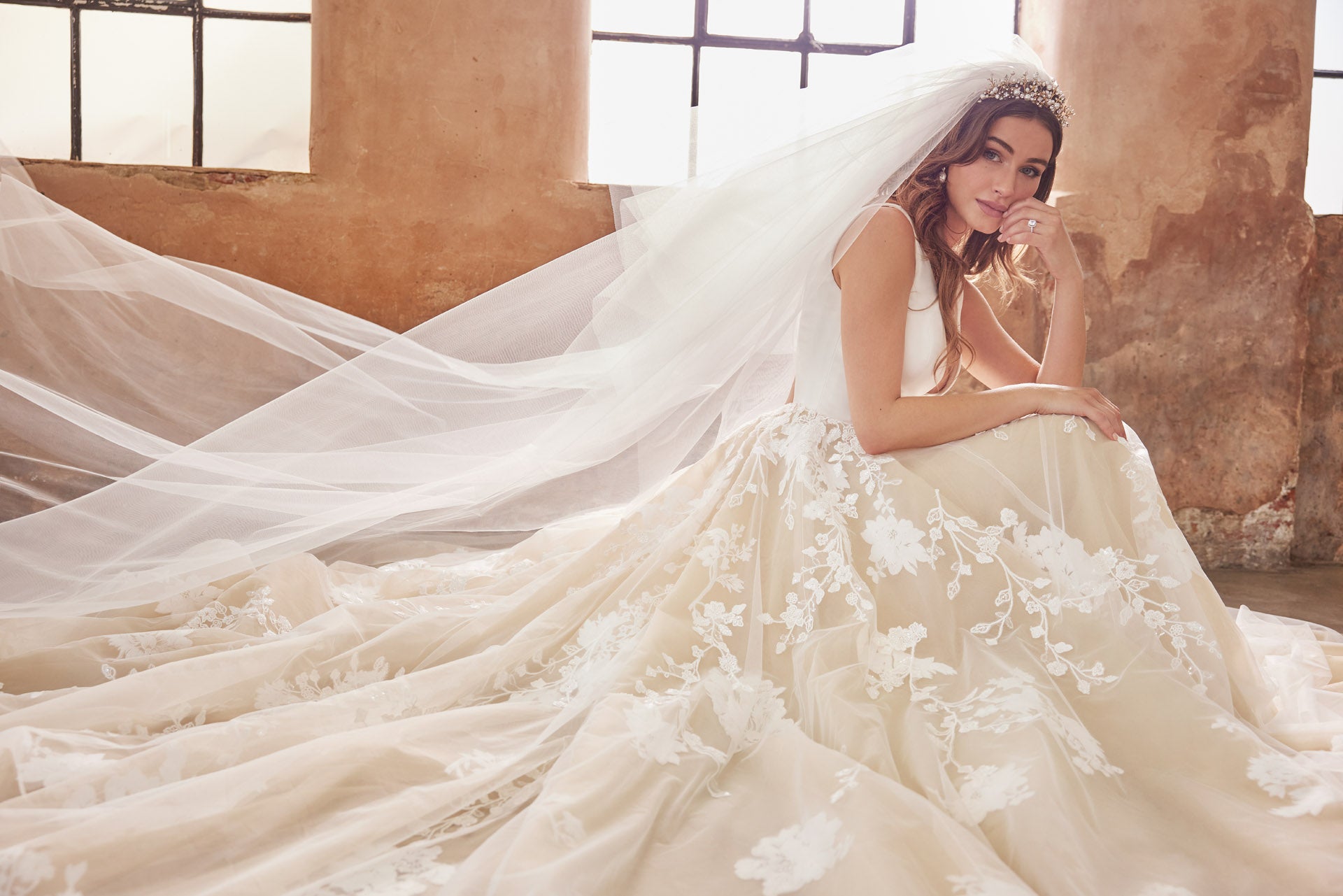 Ballgown with soft layers of tulle and floral applique lace on skirt, crepe v-neck bodice and key-hole back.