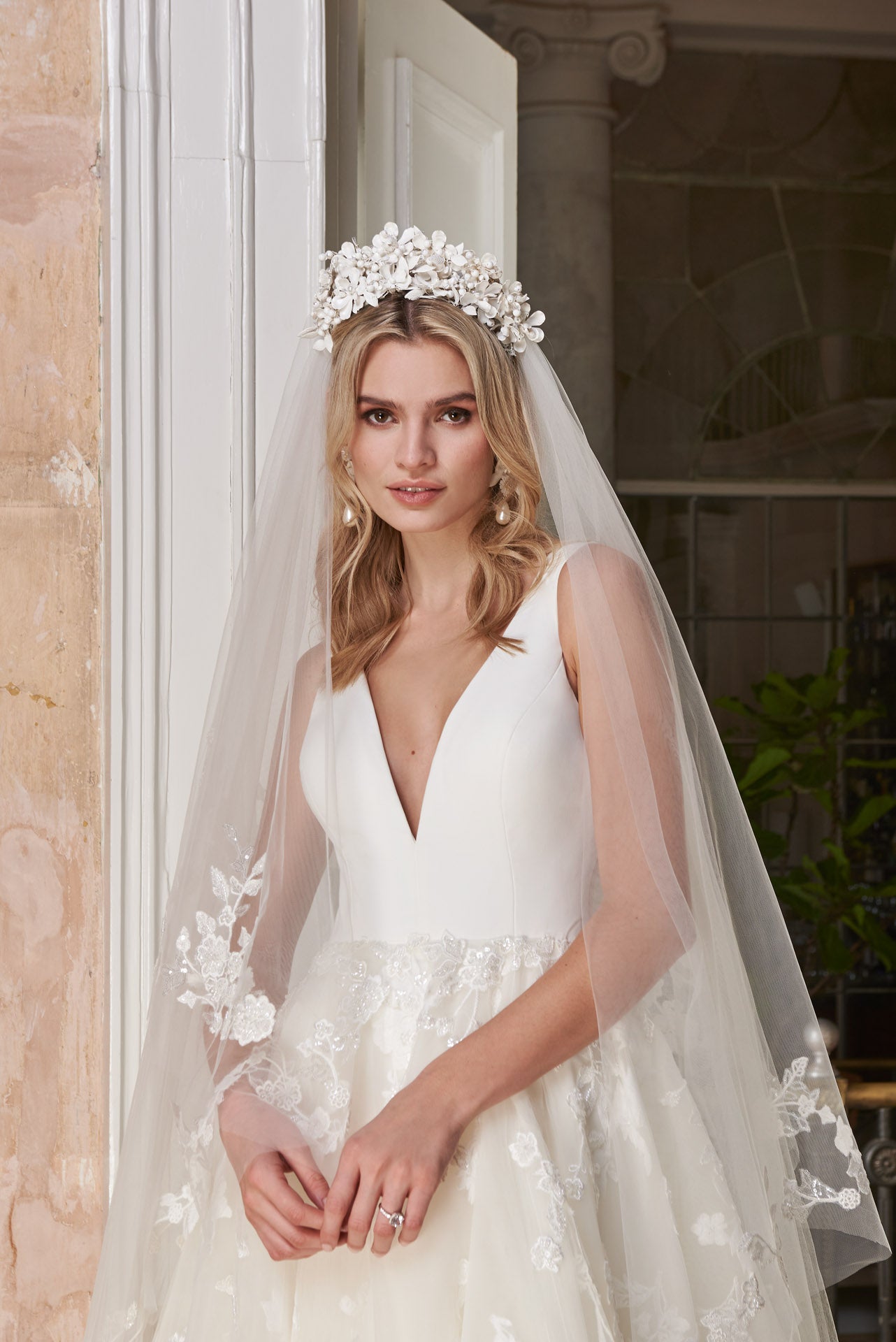 Ballgown with soft layers of tulle and floral applique lace on skirt, crepe v-neck bodice and key-hole back.