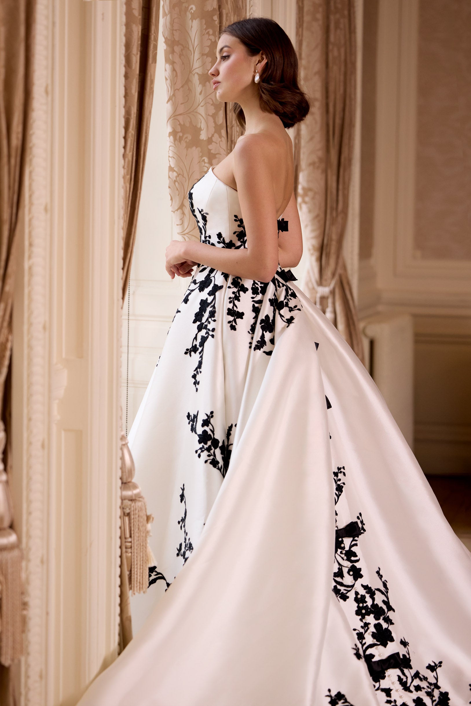 straight strapless neckline A-line dress with black lace with dramatic train and long black gloves and bows