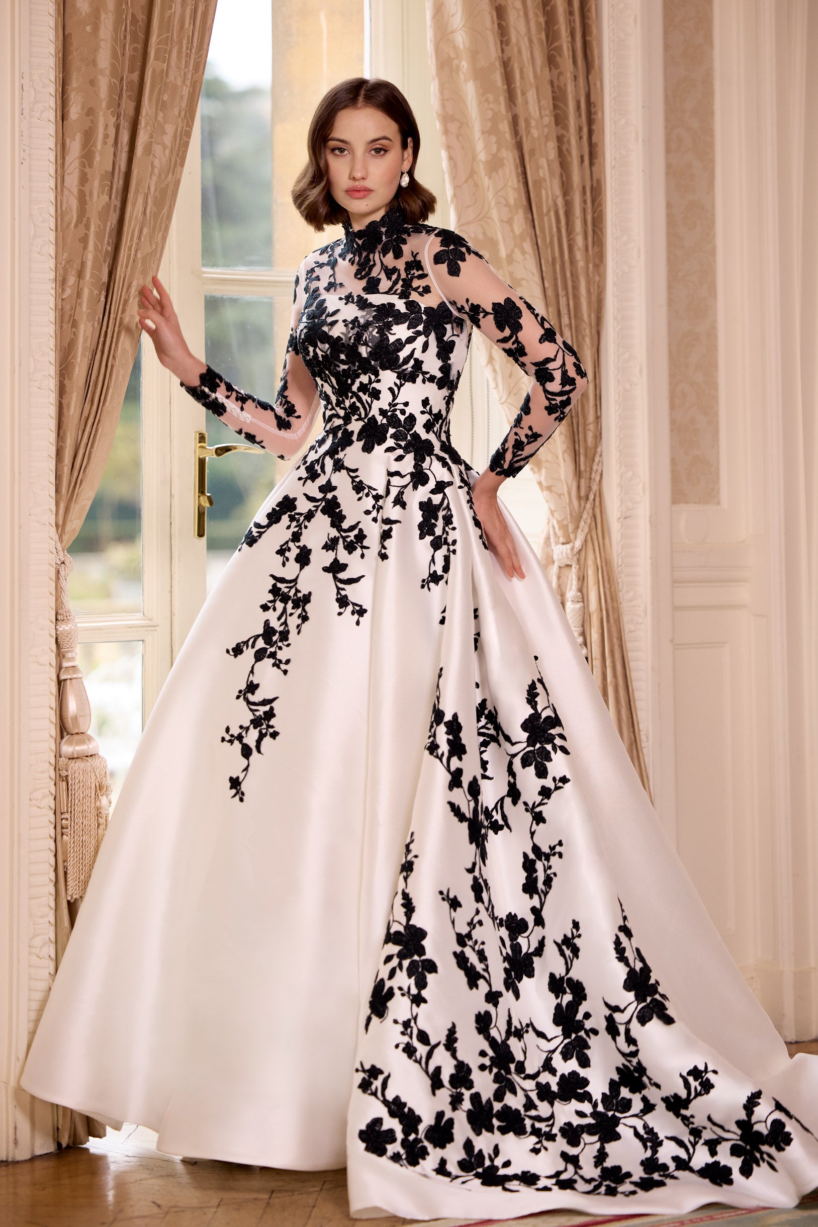 straight strapless neckline A-line dress with black lace with dramatic train and long black gloves and bows and matching black lace long sleeve topper