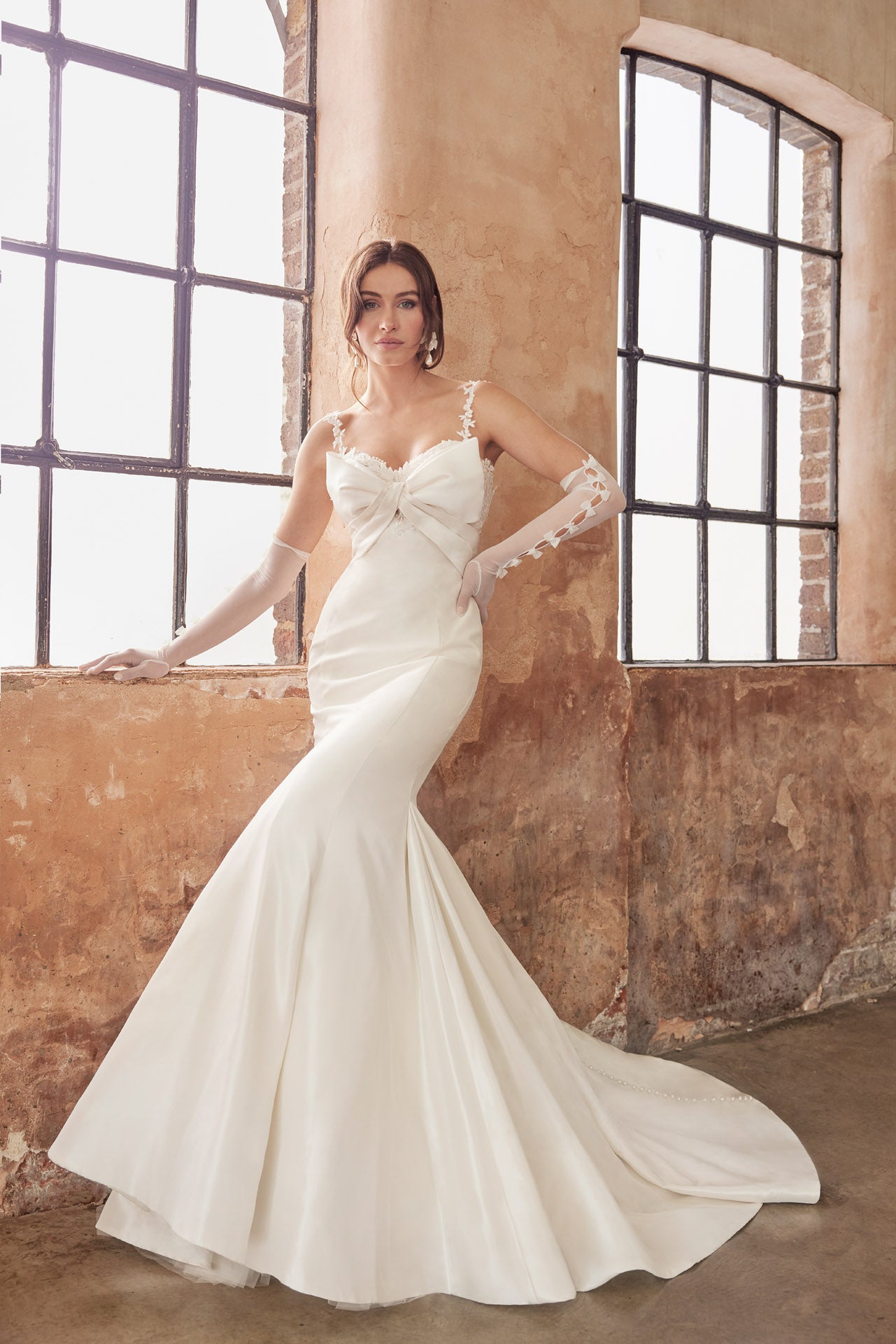 Fishtail silhouette of luxurious taffeta faced satin. Dramatic bow neckline and enviable fishtail silhouette, luxurious lace and back button detail along the train. Lace appliqued internal structured corset.