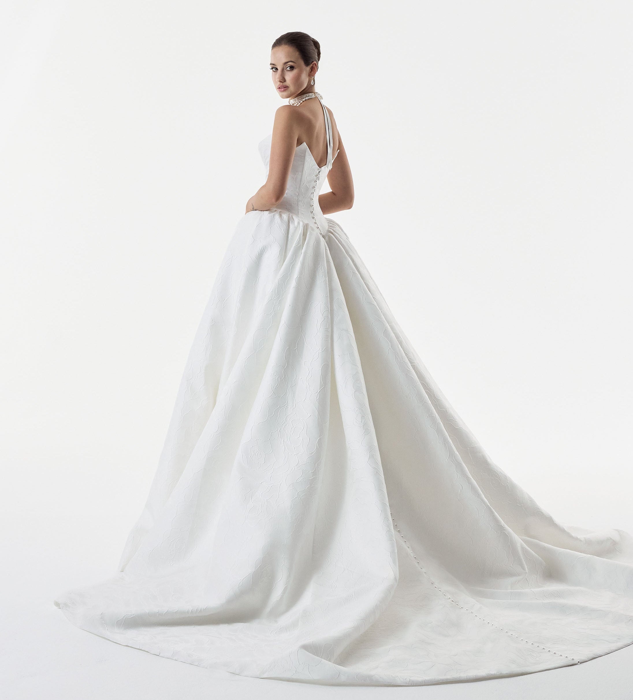 strapless cat eye neckline with sculptural structured pleated bodice and a basque waist full A-line ballgown skirt with pearl buttons