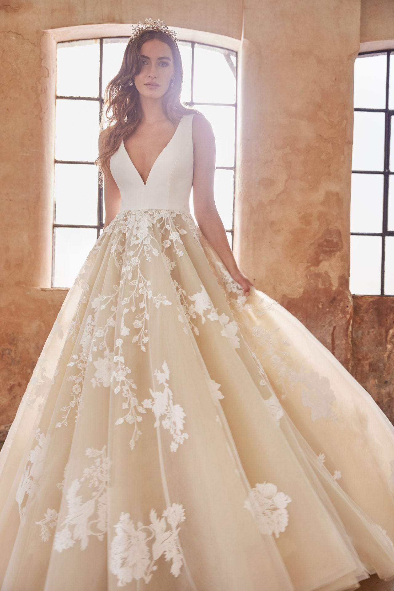 Ballgown with soft layers of tulle and floral applique lace on skirt, crepe v-neck bodice and key-hole back.