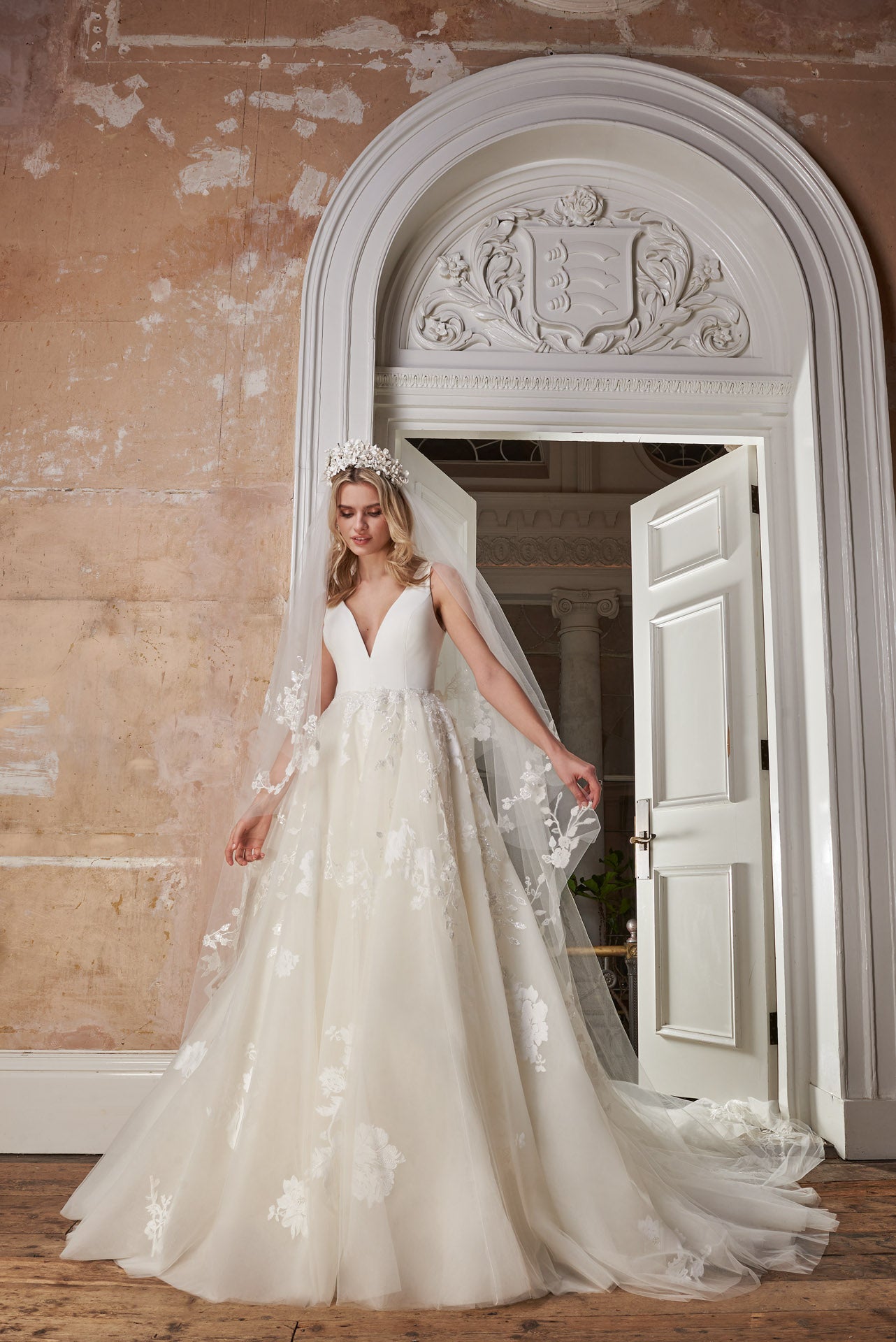 Ballgown with soft layers of tulle and floral applique lace on skirt, crepe v-neck bodice and key-hole back.