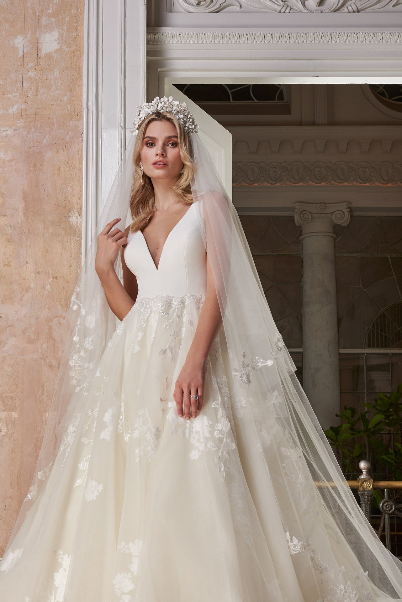 Ballgown with soft layers of tulle and floral applique lace on skirt, crepe v-neck bodice and key-hole back.