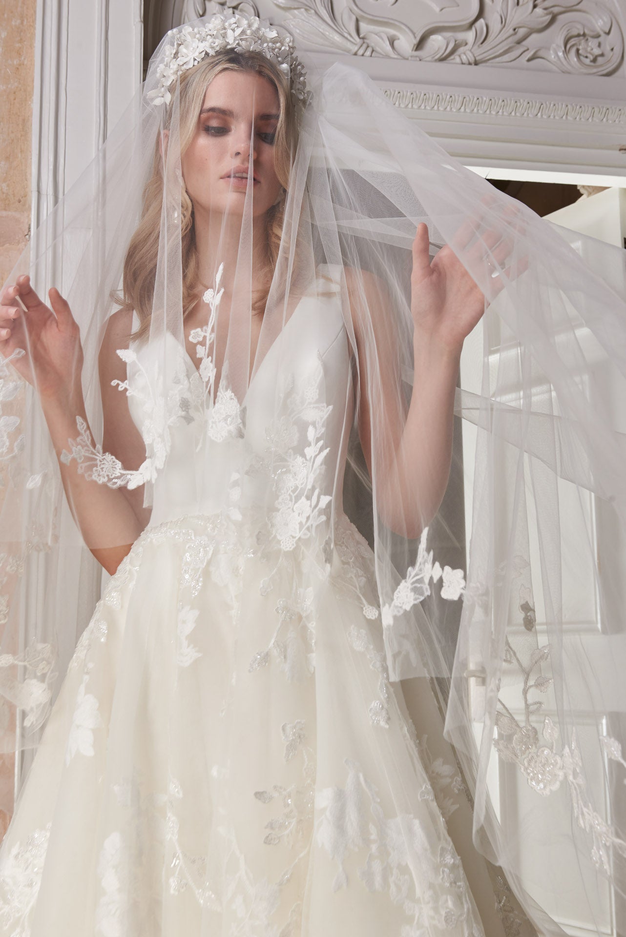 Ballgown with soft layers of tulle and floral applique lace on skirt, crepe v-neck bodice and key-hole back.