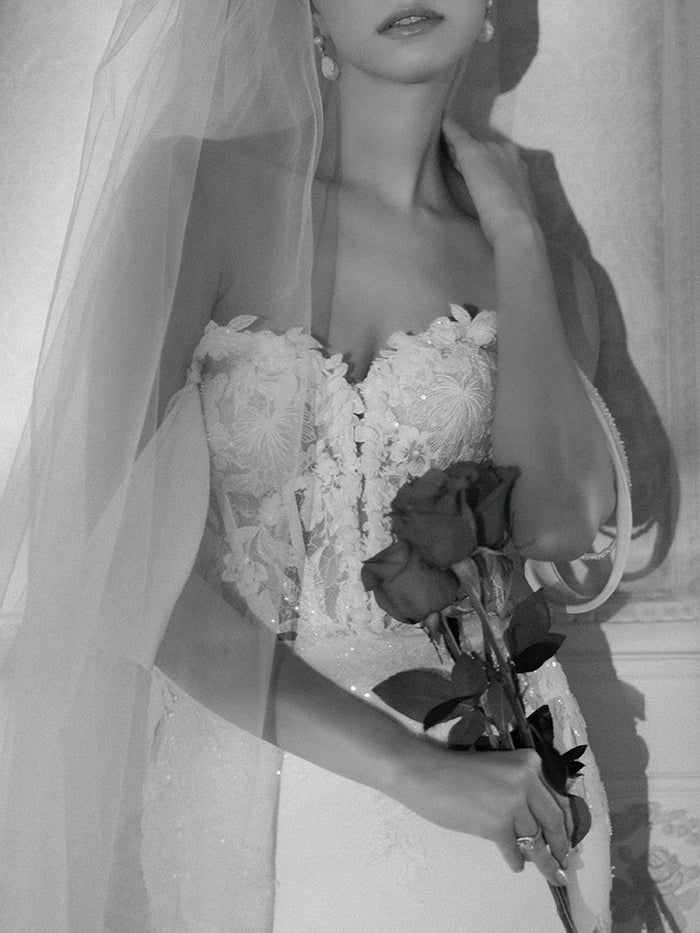 Elegant crepe sheath gown with 3D lace appliqué covered corset, detachable sleeves, delicate beaded straps and cowl back and dramatic floral lace cut-out train.